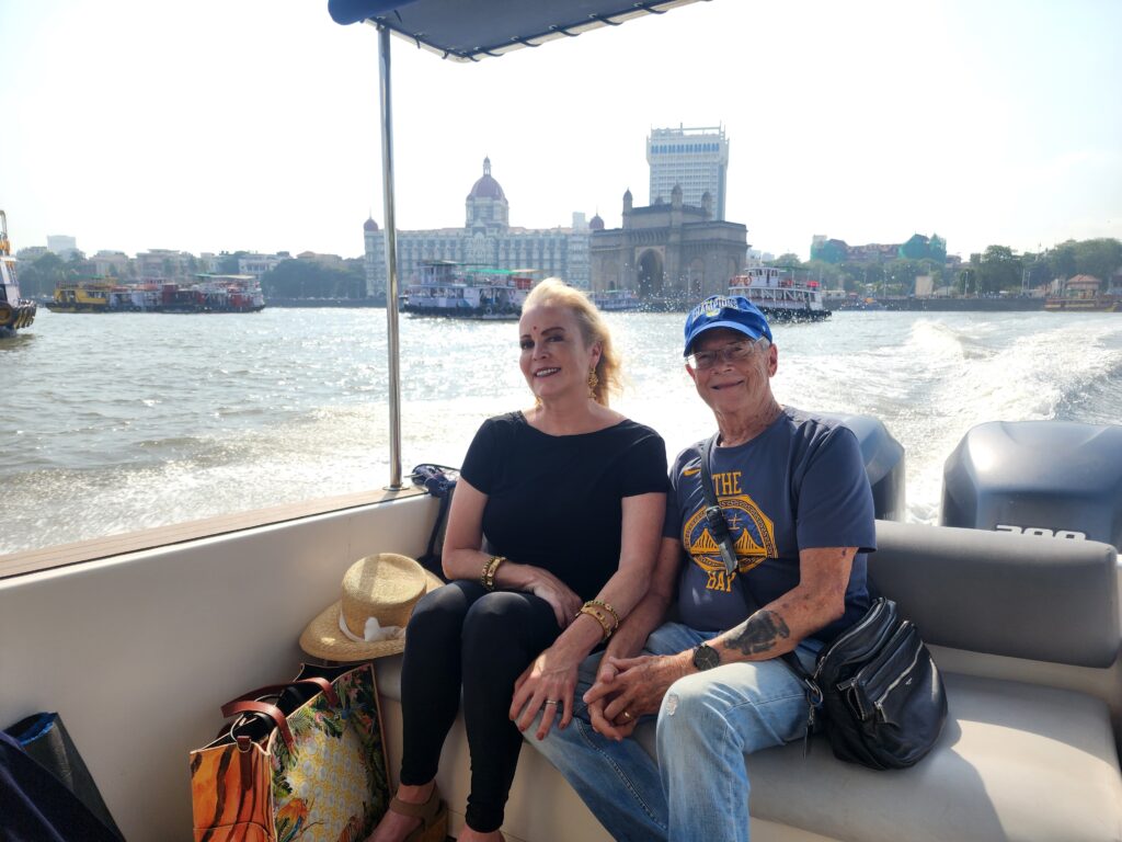 Premium Speedboat heading to Elephanta Island with the Gateway of India and Taj Mahal Palace Hotel in the background.