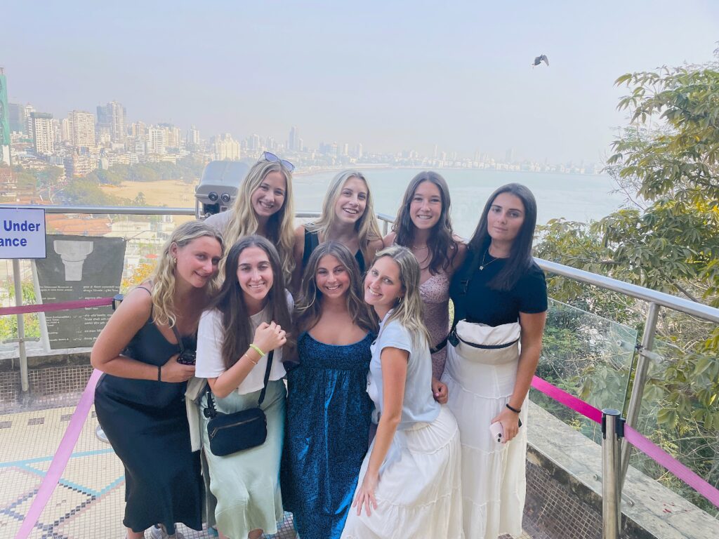 A group shore excursion travelers posing at hanging garden in front of a scenic viewpoint in Mumbai, India.