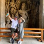 Guests posing in front of ancient sculptures at Elephanta Caves during a guided luxury shore excursion with Passport Lifestyles in Mumbai, India.