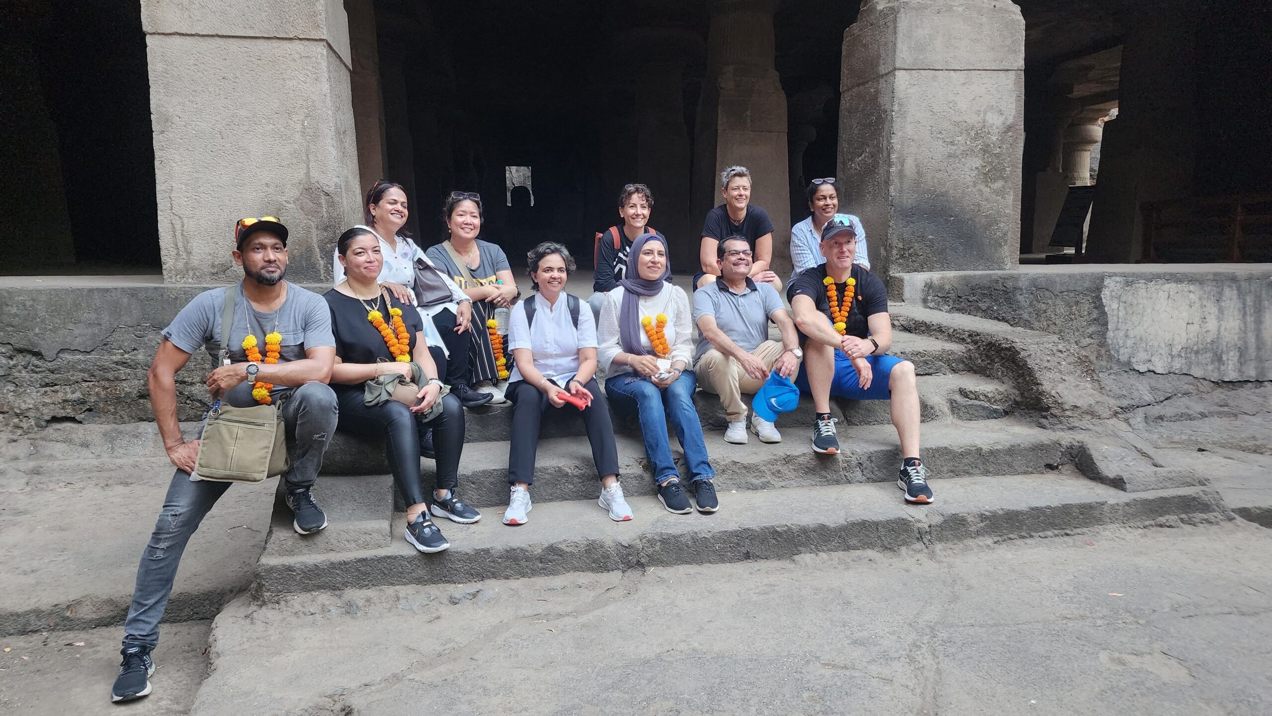 Happy tour group resting inside Elephanta Caves after a scenic speedboat journey from Mumbai harbour